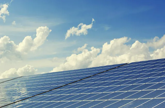 Champ de panneaux photovoltaïques sous un ciel bleu